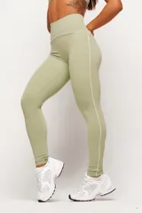 Calza deportiva de tiro alto color verde claro, con costuras laterales en contraste de color blanco que recorren la prenda desde la cintura hasta los tobillos.