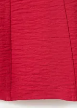 Vestido corto rojo de tirantes finos, con diseño fluido y tejido plisado.
