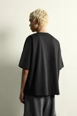 Camiseta de corte relajado color negro, con cuello redondo y manga corta. Presenta bordados a contraste en el frente con la frase 'Drop the beat' repetida en diferentes estilos tipográficos.
