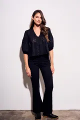 Blusa negra de algodón peinado con calce oversize, escote en V, mangas tres cuartos abullonadas y detalles de encaje y bordados en el frente y mangas.