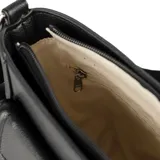 Bandolera negra de diseño compacto con textura graneada. Cuenta con un bolsillo frontal con solapa y cierre, correa ajustable de tela y herrajes plateados. Incluye logo de la marca grabado en el frente.