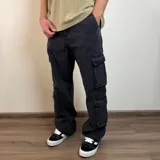 Pantalón jean cargo negro con corte holgado y múltiples bolsillos.