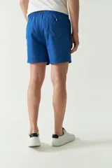 Short de baño liso con cintura elástica y cordón ajustable. Cuenta con dos bolsillos laterales, un bolsillo trasero y logo bordado. Confeccionado en tela ligera de secado rápido.