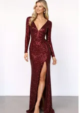 Vestido largo de fiesta color bordó, confeccionado en tela con lentejuelas brillantes. Presenta escote en V profundo, mangas largas y una abertura lateral en la falda que deja ver la pierna.