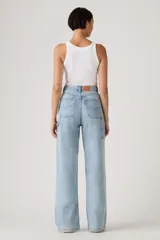 Pantalón de jean estilo carpenter con corte baggy y pierna ancha. Presenta tiro alto, bolsillos laterales y traseros, y costuras reforzadas características del diseño utilitario.