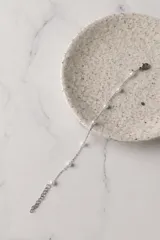Pulsera de cadena fina de acero con pequeñas perlas sintéticas distribuidas a lo largo de la pieza. Incluye una cadena de extensión para un ajuste personalizado.