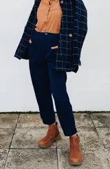 Pantalón azul marino con pinzas, tiro alto y corte tapered.