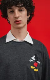 Remera de algodón premium color gris melange oscuro, con corte oversize y estampa pequeña de Mickey Mouse en el pecho.