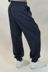Pantalon deportivo tipo babucha de color beige, con cintura elástica ajustable mediante cordón y puños elásticos en los tobillos.