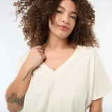 Camiseta básica de manga corta con cuello en pico, confeccionada en algodón de color blanco.
