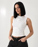 Remera sin mangas color blanco con cuello redondo drapeado y detalle de botones en el lateral inferior.