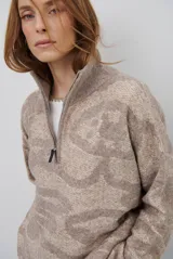 Buzo de tejido de punto con cierre frontal, cuello alto y diseño estampado en tonos beige y marrón.