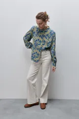 Camisa de calce amplio y fluido de viscosa liviana, con estampado de rayas verticales irregulares en blanco y negro, cuello mao, abotonadura frontal y mangas largas.