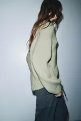 Jersey de punto grueso con cuello redondo, manga larga y diseño de bajo asimétrico.