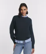 Suéter de tejido de punto color verde oscuro, de corte clásico con cuello redondo y manga larga.