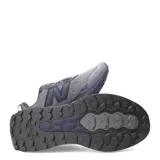 Championes de trail running New Balance modelo Garoe, en color gris con suela y detalles en azul marino. Confeccionados con capellada de malla transpirable y refuerzos sintéticos, cuentan con entresuela con tecnología Fresh Foam y suela con tacos para mayor tracción en terrenos difíciles.
