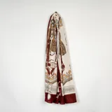 Pashmina rectangular con estampado de motivos ecuestres y borlas en tonos bordó, beige y dorado, con borde inferior en color bordó sólido.