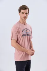Remera verde pistacho de manga corta y cuello redondo, con diseño gráfico estampado en el frente con inscripciones y tipografías en tonos oscuros y blancos.