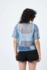 Top de manga corta, corte holgado, confeccionado en tejido de malla translúcido con brillo metálico y estampado tipo paisley en tonos azules.