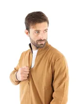 Campera tejida color camel con cierre frontal, cuello alto y puños y ruedo en color azul marino.