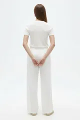 Pantalón de viscosa color blanco, con bolsillos laterales y corte recto.