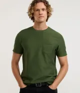 Remera de hombre color verde oliva, manga corta, cuello redondo y un bolsillo de parche en el pecho. La tela presenta una textura acanalada o de punto fino en relieve.