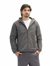 Campera rompevientos de nylon color negro, con capucha ajustable, cierre frontal, bolsillos laterales con cierre y forro interno de red para mayor ventilación.