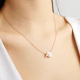 Collar dorado con dije de mariposa con incrustaciones de strass.