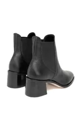 Botín tipo Chelsea confeccionado en cuero vacuno con textura floater. Presenta paneles laterales elásticos, punta ligeramente cuadrada y tacón de bloque.