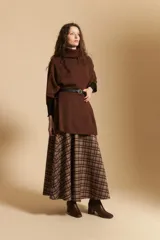 Poncho de tejido de punto color gris, con cuello alto y mangas amplias de diseño holgado.
