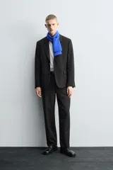 Pantalón de traje corte straight fit confeccionado en tejido mezcla de lana. Presenta cierre frontal con cremallera y botón, bolsillos laterales y bolsillos traseros de vivo.