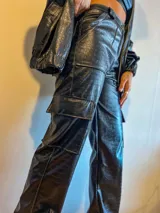 Pantalón cargo de cuero sintético negro con estampado croco, corte recto y bolsillos laterales.