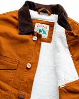 Campera de estilo workwear color camel, confeccionada en canvas resistente con interior de corderito sherpa. Presenta cuello de pana en color marrón oscuro, cierre frontal con botones metálicos color cobre, cuatro bolsillos frontales y un bolsillo interior.