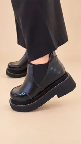 Botín Selene de estilo urbano y color negro, con diseño de caña baja, elásticos laterales y suela de plataforma robusta.