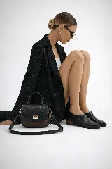 Zapato tipo botineta de cuero vacuno color negro, con diseño de punta fina y elásticos laterales. Presenta un taco cuadrado de madera de 5 cm de altura y suela de caucho.