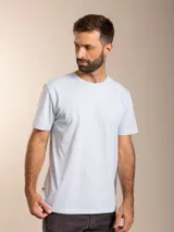 Remera de algodón color azul, de corte clásico con cuello redondo y manga corta. Presenta un pequeño bordado distintivo de un ave en el pecho.