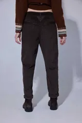 Pantalón de corte recto y tiro medio, confeccionado en tejido con patrón de cuadros oscuros. Presenta bolsillos frontales amplios y terminación con dobladillo en los tobillos.