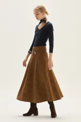 Falda midi acampanada de color camel, confeccionada en material con textura similar al cuero gamuzado.