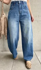 Jean de denim azul de tiro alto, con silueta barrel de corte ancho y relajado.