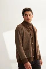 Cardigan marrón tejido con cuello smoking, cierre con botón y bolsillos delanteros.