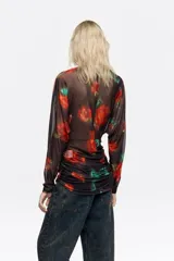 Camiseta de tul de manga larga con escote barco, diseño ajustado y efecto fruncido en los laterales del bajo. Presenta un estampado de flores rojas sobre fondo oscuro.