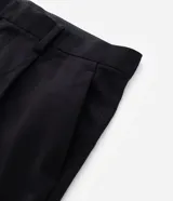 Pantalón de vestir beige de corte wide leg, con trabillas para cinto, bolsillos y diseño de sastrería.