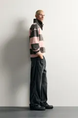 Jeans de denim de algodón en color azul con efecto desgastado, tiro medio y corte recto de ajuste holgado (loose fit). Cuenta con diseño clásico de cinco bolsillos y cierre frontal con cremallera y botón.