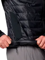Chaqueta híbrida para hombre con cuerpo acolchado y mangas de tejido softshell liso. Presenta cierre frontal completo, cuello alto y logo de la marca estampado en el pecho. Diseñada con tecnología repelente al agua y aislamiento térmico sintético.