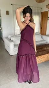 Vestido largo color bordó con escote halter y detalles de volados diagonales.