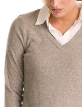 Buzo combinado marca Rio & Rian, con diseño de efecto capas que simula una camisa blanca debajo. Presenta un cuerpo de tejido de hilado fino en color beige con escote en V, y cuello y ruedo de gasa blanca.