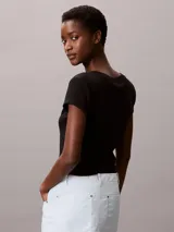 Remera de Calvin Klein confeccionada en punto de algodón elástico con textura de canalé fino. Presenta un diseño de corte slim, cuello en V, manga corta y una insignia con el logo de la marca en el pecho.