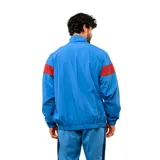 Buzo deportivo Umbro del Club Nacional de Football, con medio cierre frontal, cuello alto y diseño en bloques de color azul, blanco y bordó. Presenta el logo de la marca y el escudo del club en el pecho.