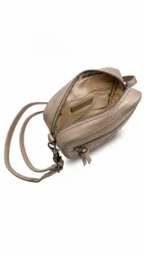 Bandolera de tamaño compacto en color tostado, confeccionada en símil cuero. Presenta dos bolsillos frontales con cierre, un parche decorativo negro con logo y correa ajustable y desmontable en color negro.