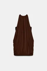 Vestido corto marrón con cuello halter y hombros descubiertos. Tiene detalle de tejido drapeado en los laterales y bajo abullonado con elástico. El forro interior está combinado con aplicación de lentejuelas.
